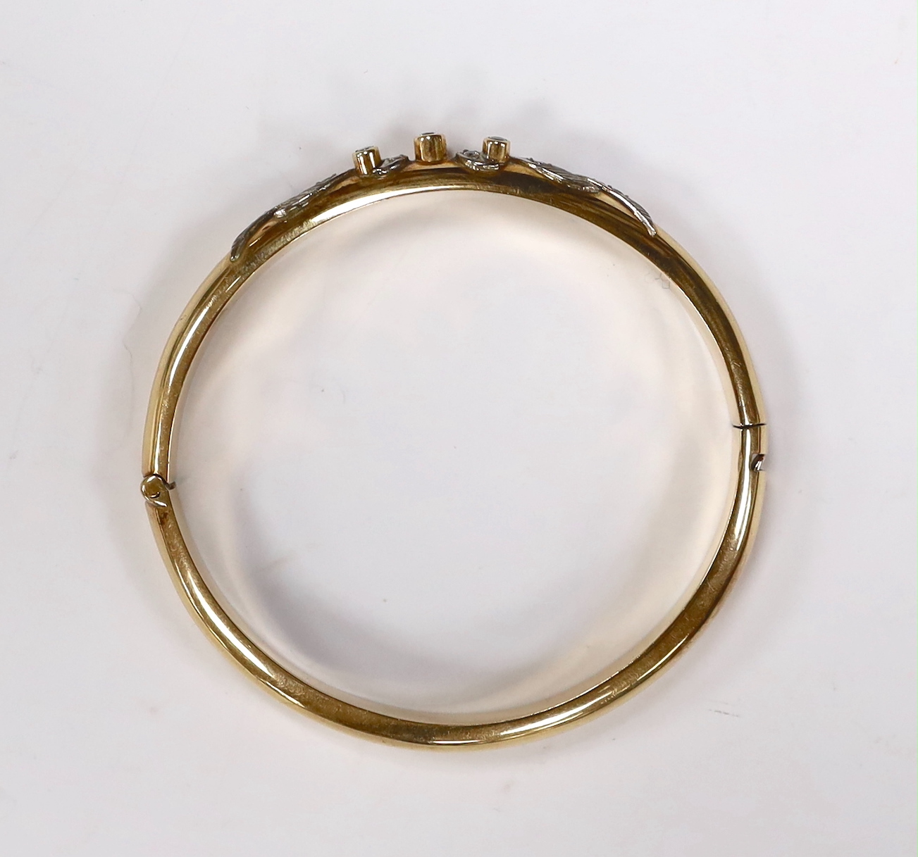 A 585 yellow metal and simulated diamond set hinged bangle, gross weight 20 grams.